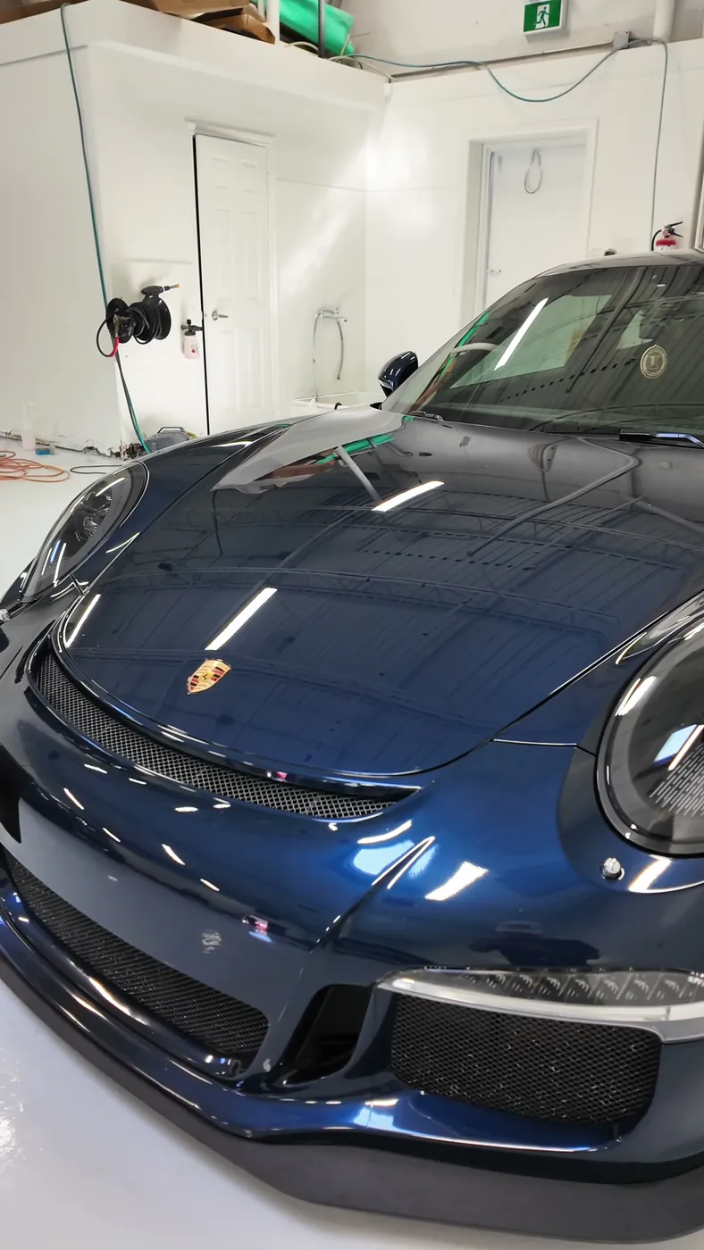 Dark blue Porsche 911 GT3 with Ontario plates, finished inside a certified partner bay