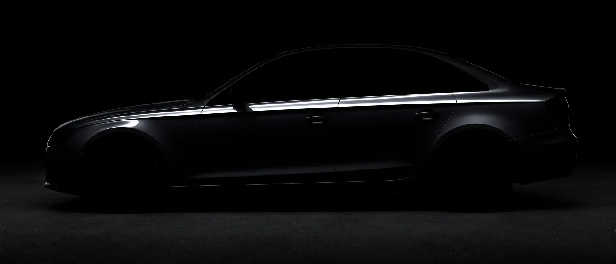 A dark saloon in profile, close to silhouette, one hard highlight along the shoulder line