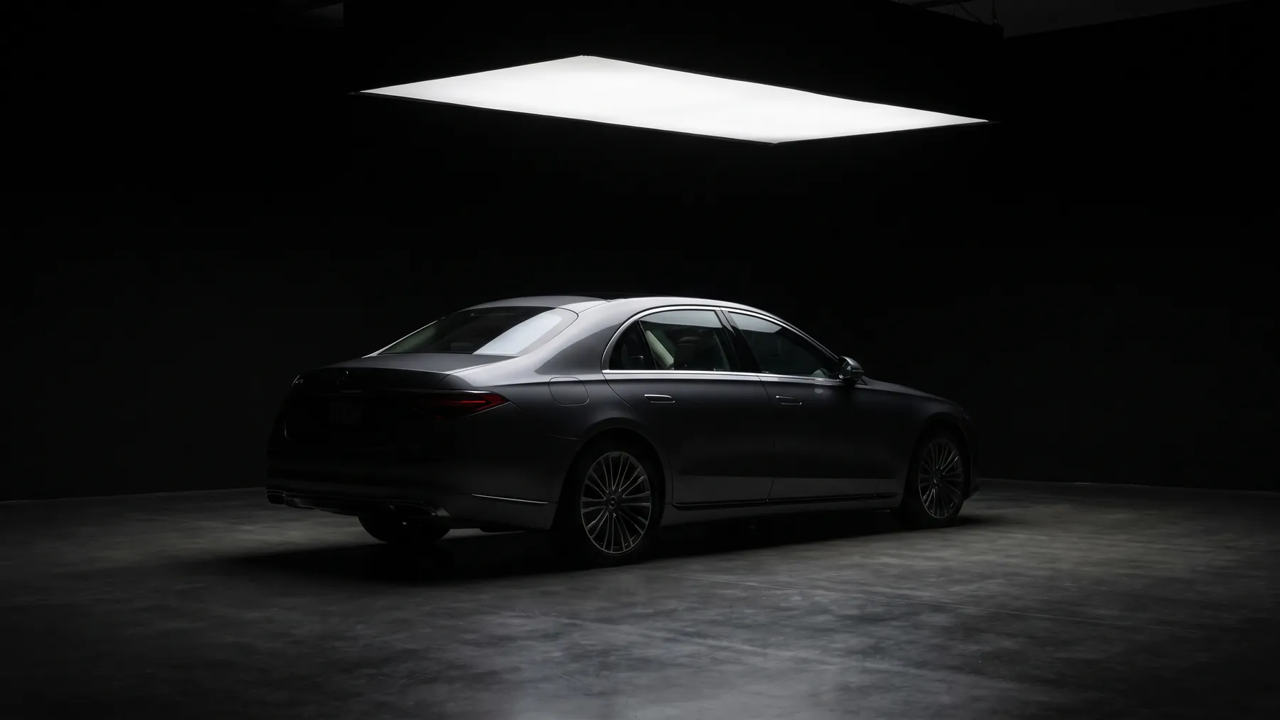 A dark saloon, rear three quarter, under a single overhead softbox in a very dark studio