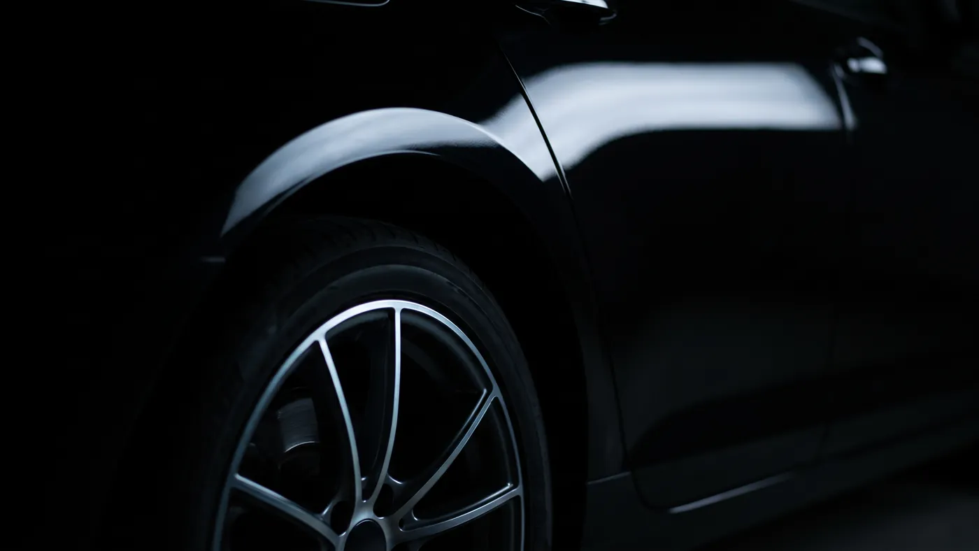 Macro of a coated rear arch and lower flank, one highlight sitting on the wheel